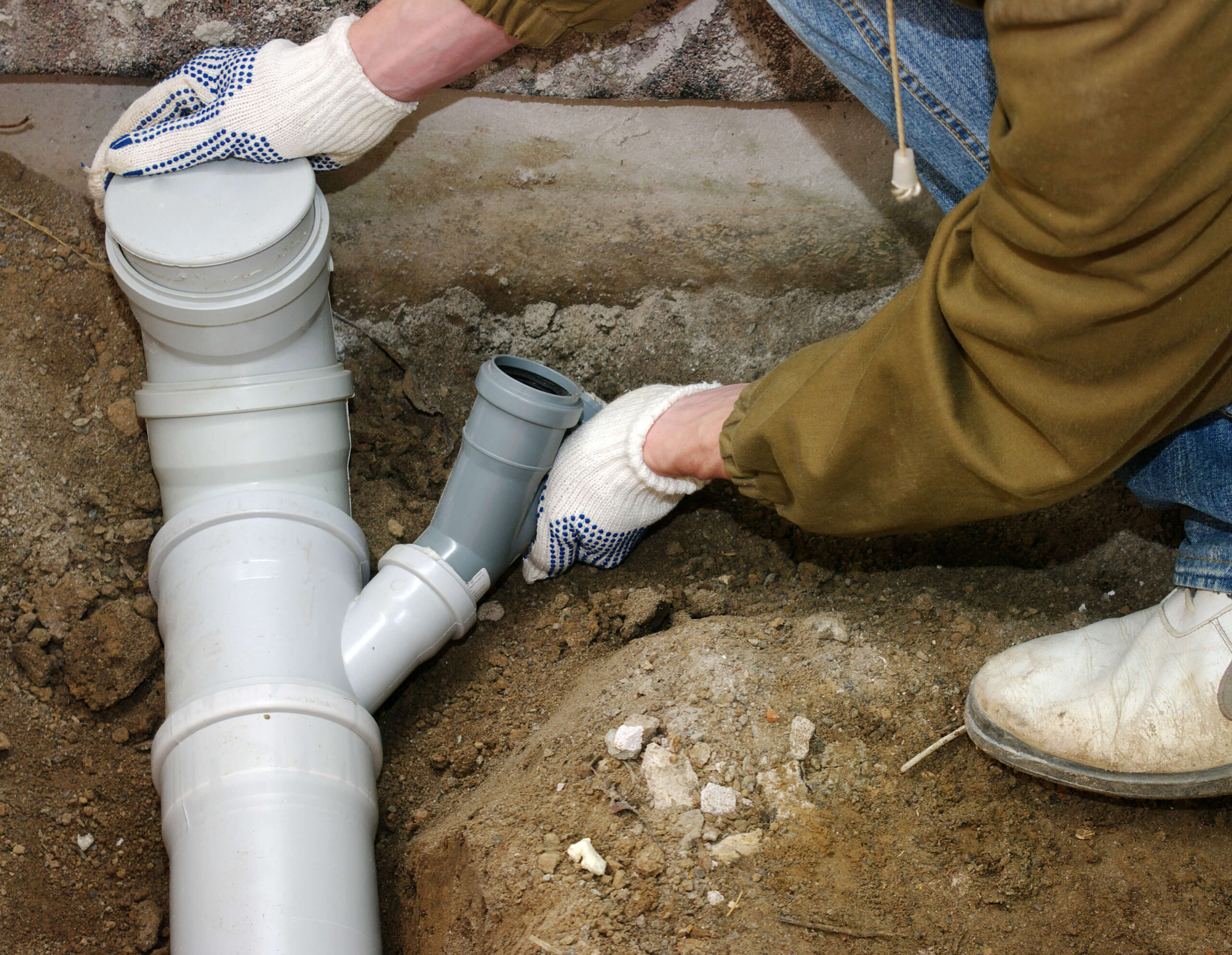 Technician inspecting sewer line installation to ensure proper alignment and efficient water flow in the system.