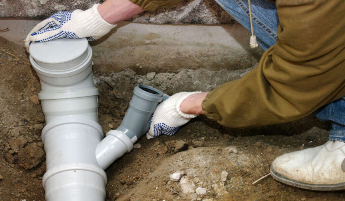 a professional repairing the pipe to avoid plumbing code violation