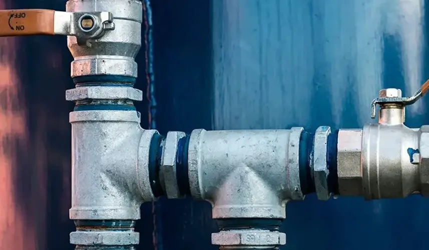 A close-up of a commercial plumbing system with metal pipes and valves, illustrating commercial plumbing services.