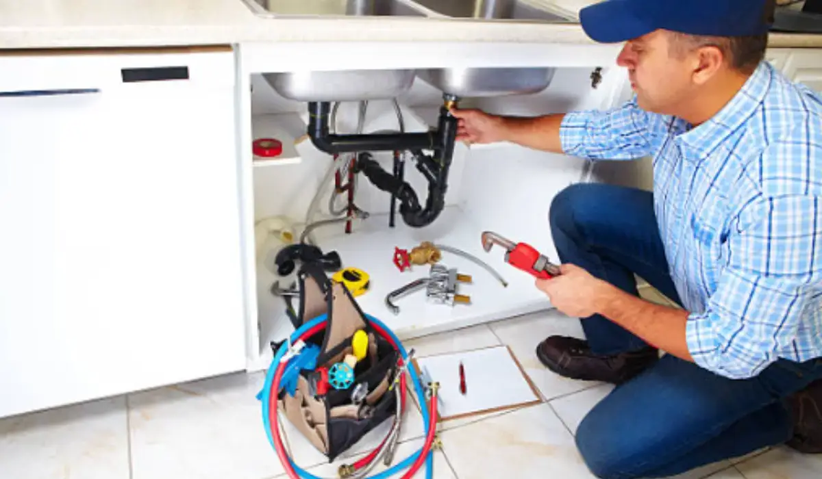 Plumber repairing kitchen sink to fix plumbing problems that could jeopardize a successful home sale in Naperville.