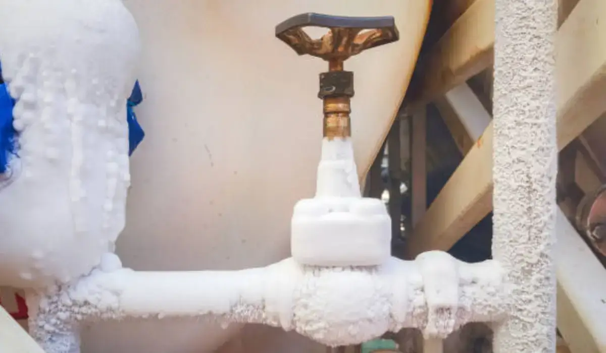 Frozen pipes covered in ice during winter, highlighting the importance of proper insulation and prevention for Naperville homeowners.