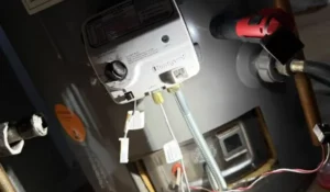 Close-up of a residential water heater control panel inspected during winter repair service in Naperville basement.