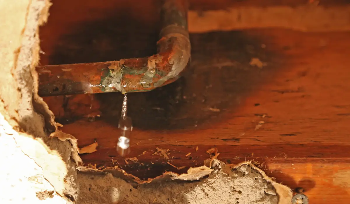 Leaking, corroded copper pipe inside wall contributing to low water pressure in a Naperville home—a common hidden plumbing issue.