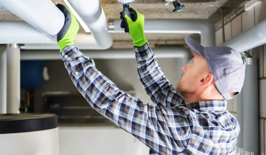 Plumber performing fall plumbing maintenance in Naperville IL, inspecting home pipes before winter.