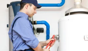 Technician adjusting residential water heater during replacement service to prepare the system for heavy winter demand.